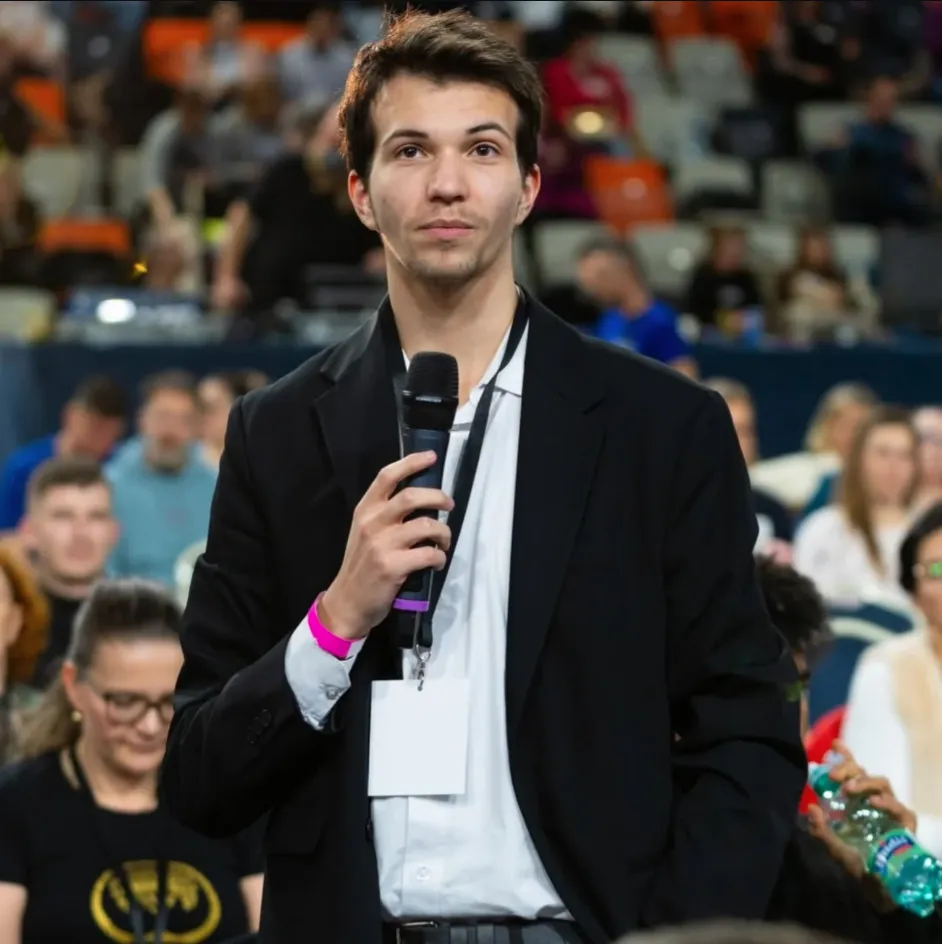 Richard Vavřena na pódiu s mikrofónom